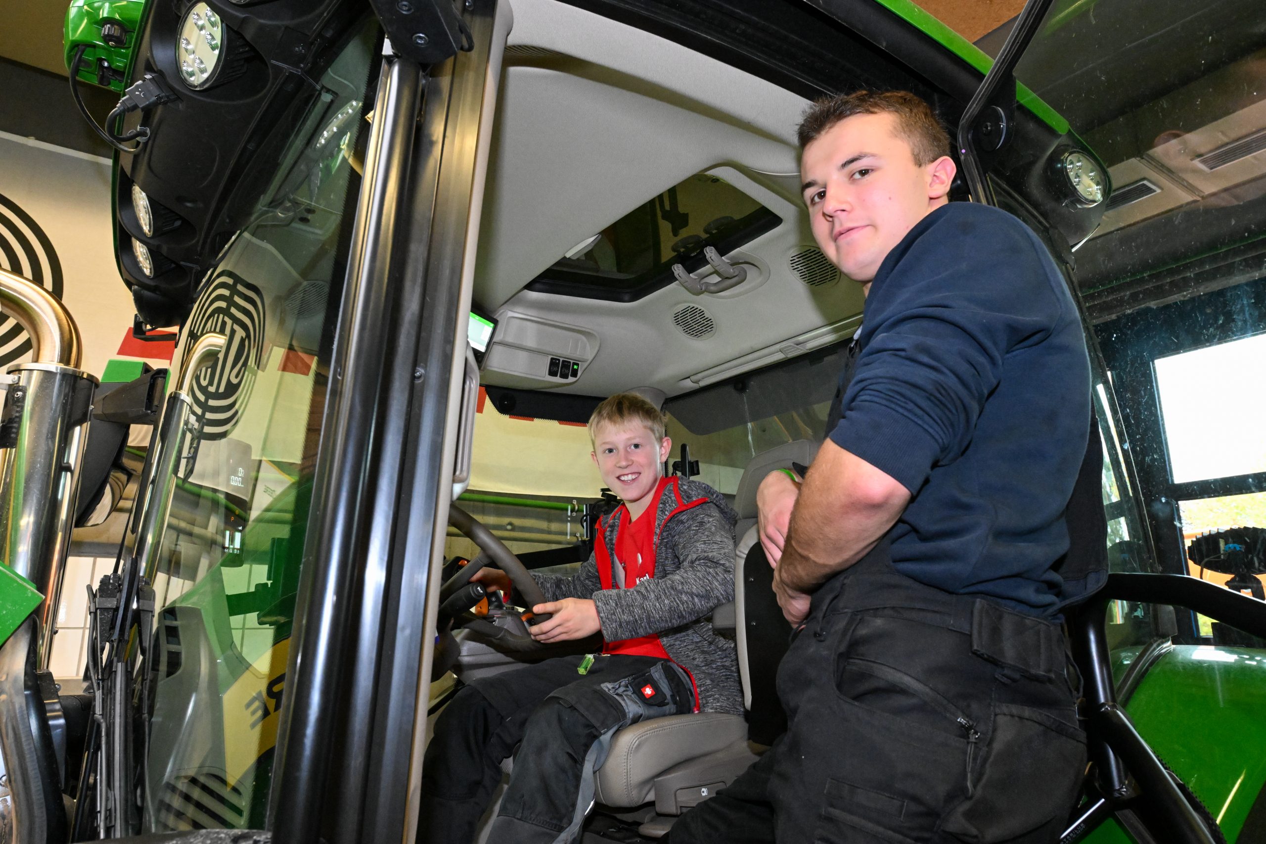 Ein Jugendlicher sitzt in einem Traktor.