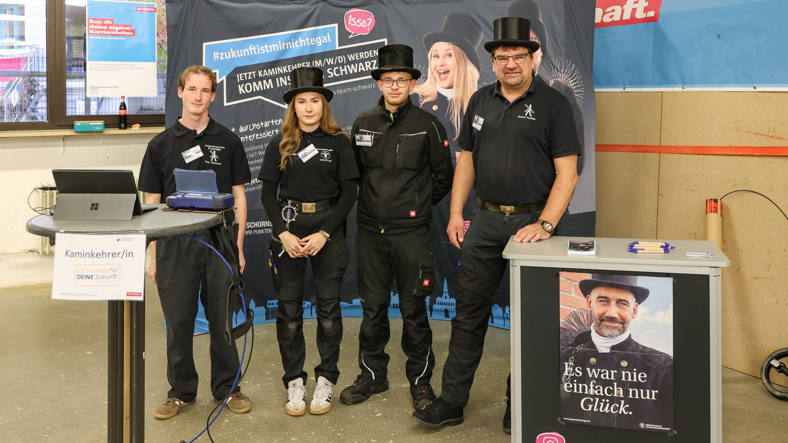 Das Team eines Kaminkehrerbetriebs posiert für ein Gruppenbild.