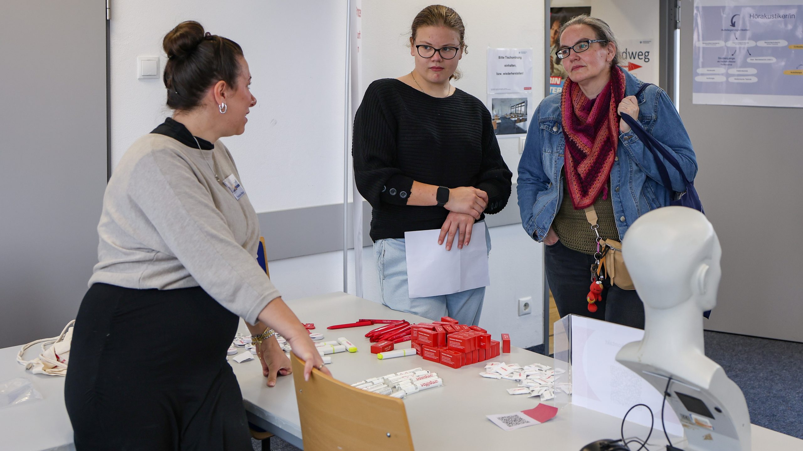 Eine Mutter und ihre Tochter informieren sich am Stand eines Hörakustikerbetriebes.